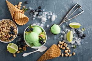 Green refreshing lime pistachio ice cream in white bowl overhead shot