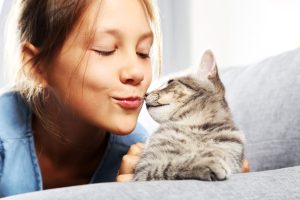 women trying to kiss a cute cat